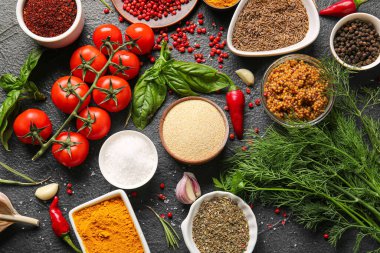 Esmer arka planda aromatik baharatlar, sebzeler ve otlarla kompozisyon