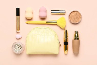 Pembe arka planda çanta, makyaj malzemesi ve makyaj malzemesi kompozisyonu