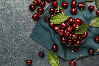 Koyu renkli arka planda olgun kirazlı kompozisyon