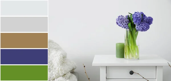 Vase with hyacinth flowers on table near light wall. Different color patterns