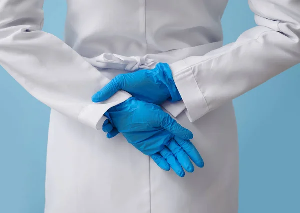 Lekarz Trzymający Się Ręce Gumowych Rękawiczkach Plecami Niebieskim Tle Zbliżenie — Zdjęcie stockowe