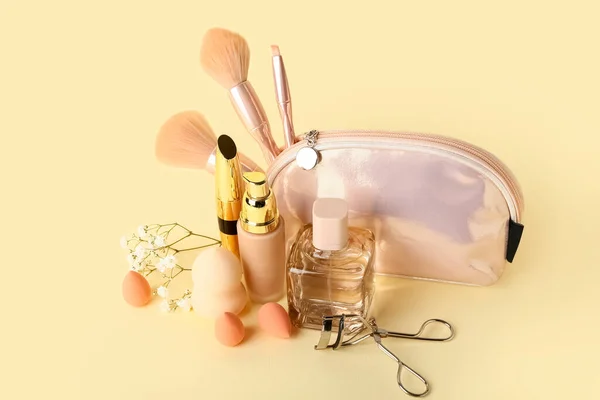 Set of different cosmetics and makeup accessories on color background