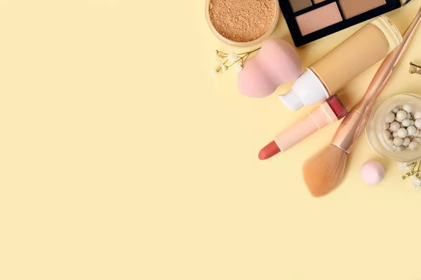 Composition with different cosmetics and makeup accessories on color background