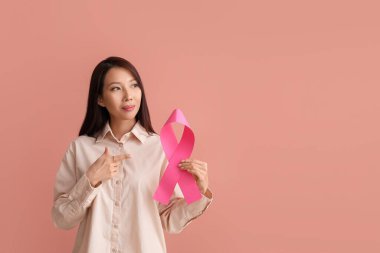 Pembe kurdeleli genç bir Asyalı kadın. Göğüs kanseri farkındalığı konsepti