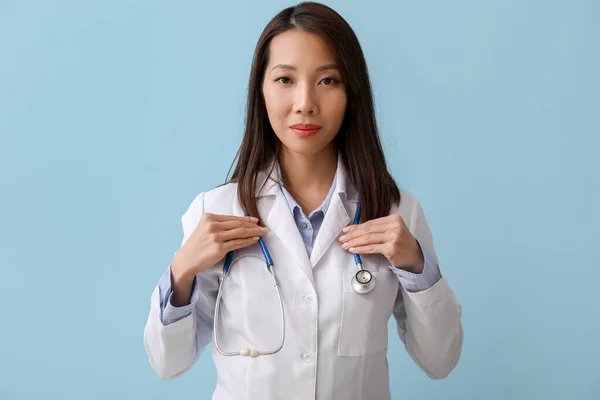 Female Asian doctor on blue background
