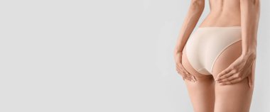 Buttocks of slim young woman in underwear on light background with space for text
