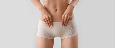 Young woman in underwear on light background, closeup
