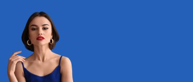 Mavi arkaplanda kırmızı dudakları olan güzel genç bir kadın.