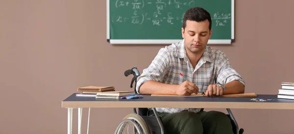 Male Teacher Wheelchair Checking Homework Table Classroom — Stok fotoğraf