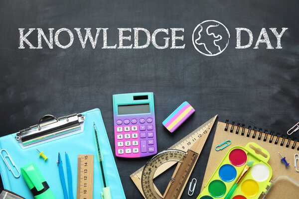 School stationery on dark blackboard. Knowledge Day