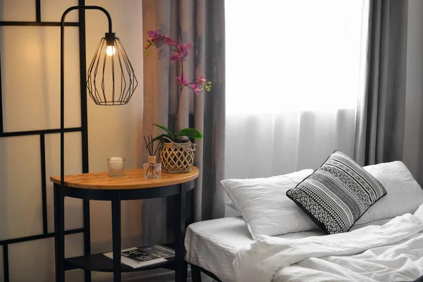 时尚居室中的花桌 芦苇扩散器和发亮的灯 — 图库照片
