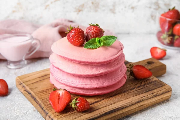 木木板 配上美味的粉红色薄饼和浅色背景的草莓 — 图库照片