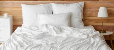 Odasında temiz çarşaf olan büyük, rahat bir yatak.