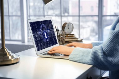 Young woman using laptop with locked screen at table. Concept of online safety