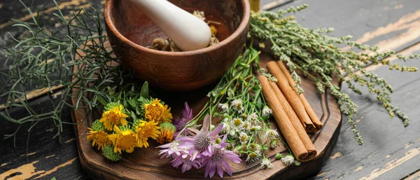 Koyu ahşap arka planda farklı otlar taşıyan havan topu.