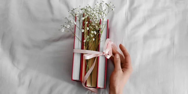 Female Hand Books Tied Ribbon Flowers Bed — Stockfoto