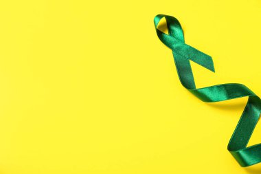 Sarı arka planda yeşil kurdele. Karaciğer kanseri kavramı