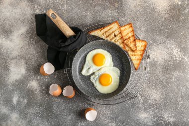 Kızarmış yumurtalı tava, grunge arkaplanda tost ve kabuk.
