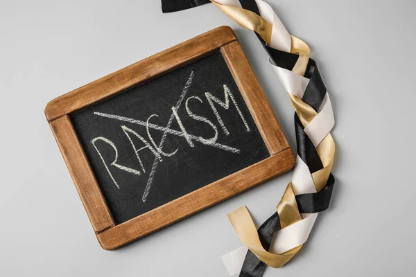 Chalkboard Διαγραμμένη Λέξη Racism Και Πλεγμένες Κορδέλες Γκρι Φόντο — Φωτογραφία Αρχείου