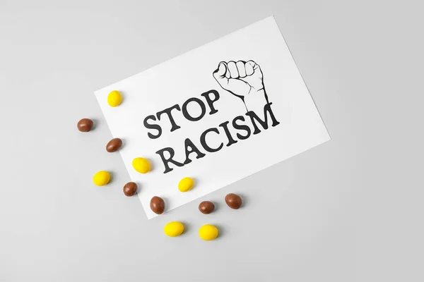 Καραμέλες Και Φύλλο Χαρτιού Κείμενο Stop Racism Γκρι Φόντο — Φωτογραφία Αρχείου