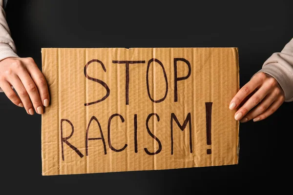Χέρια Κρατώντας Κομμάτι Του Χαρτοκιβωτίου Κείμενο Stop Racism Σκούρο Φόντο — Φωτογραφία Αρχείου