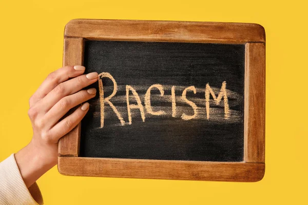 Ανθρώπινο Χέρι Κρατώντας Chalkboard Γραπτή Λέξη Racism Στο Φόντο Χρώμα — Φωτογραφία Αρχείου