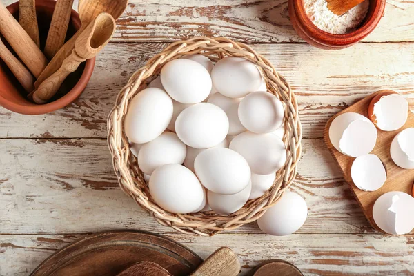 Hasır sepet, hafif ahşap arka planda yumurtalar.