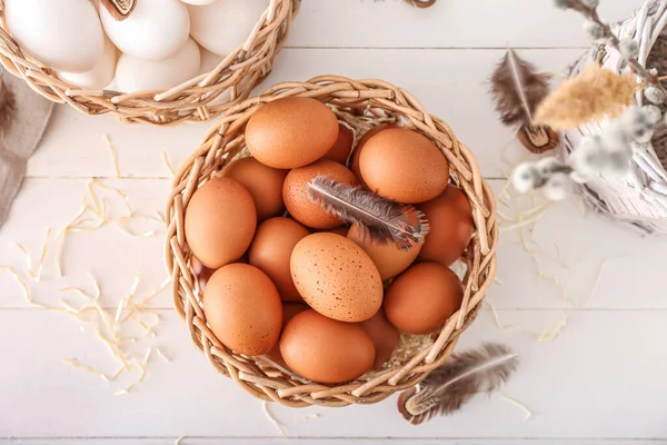 Ψάθινα Καλάθια Αυγά Κοτόπουλου Και Φτερά Λευκό Ξύλινο Φόντο — Φωτογραφία Αρχείου