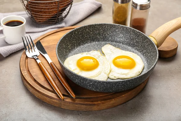 Wooden Board Frying Pan Tasty Eggs Cutlery Grunge Background — Zdjęcie stockowe