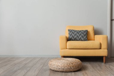 Odadaki ışık duvarının yanında rahat sarı koltuk