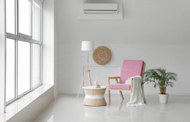 Odada lamba, masa ve çiçekli rahat bir koltuk var.