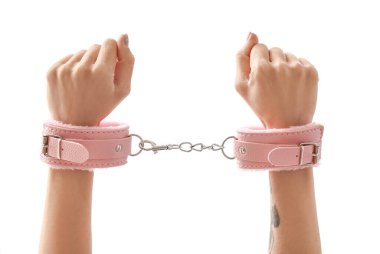 Beyaz arka planda seks dükkanından kelepçeli kadın elleri.