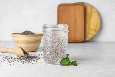 Masada bir bardak sağlıklı içecek ve chia tohumu.