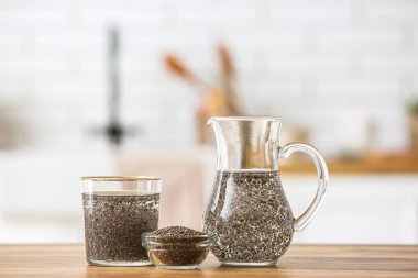 Bir bardak su, sürahi ve kase. Mutfaktaki masada Chia tohumları var.