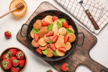 Mini krep, çilek ve bal arka planda, yakın plan.