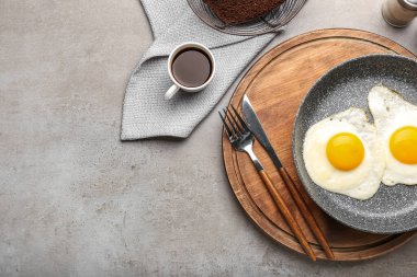 Lezzetli yumurtalı ahşap tahta tahta ve grunge arka planda bir fincan kahve.
