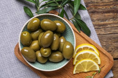 Tahta masada yeşil zeytin ve limon dilimleri olan bir masa. Yakın plan.
