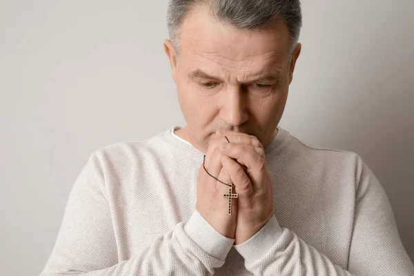 Praying Mature Man Cross Light Background — Stockfoto