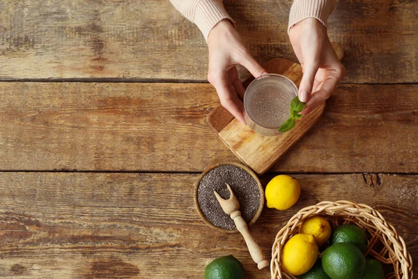 Woman Adding Mint Leaves Glass Drink Chia Seeds Wooden Table — Stock Photo, Image