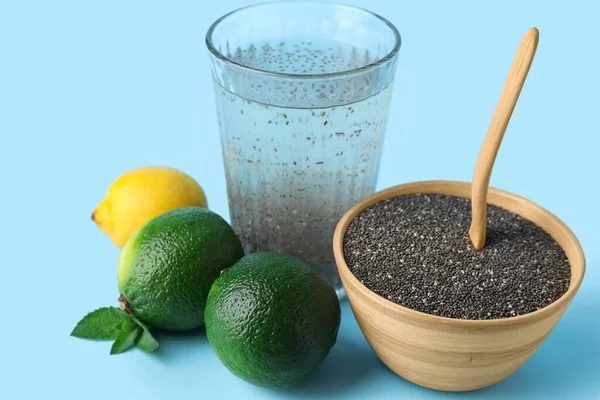 Bir bardak sağlıklı içecek, chia tohumlu kase ve mavi arka planda narenciye meyvesi, yakın plan.