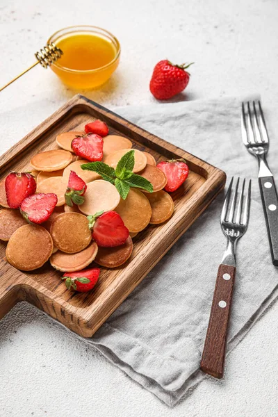 Holzbrett Mit Mini Pfannkuchen Und Leckeren Erdbeeren Auf Hellem Tisch — Stockfoto