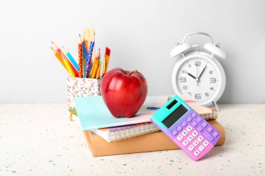 Elma ve alarmlı okul kağıtları gri arkaplanda.