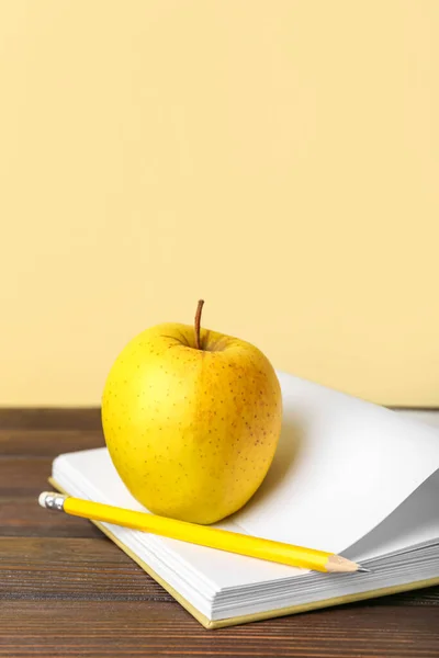 Libro Escolar Con Manzana Lápiz Sobre Mesa Sobre Fondo Color — Foto de Stock