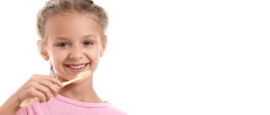 Beyaz arka planda dişlerini fırçalayan küçük bir kızın portresi.