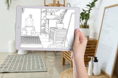 Designer holding tablet computer with drawing of new restroom interior