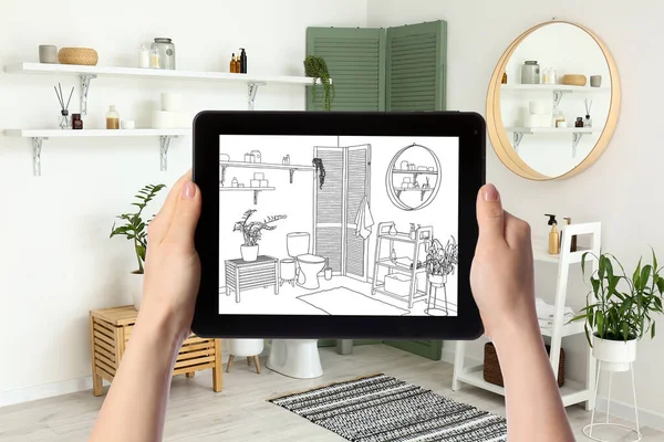 Designer holding tablet computer with drawing of new restroom interior