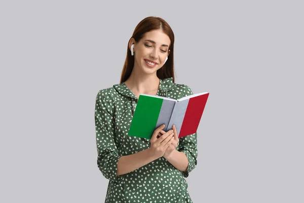 Young Woman Earphones Book Light Background Concept Studying Italian Language — Foto de Stock