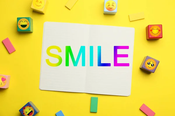 Open Notebook Word Smile Cubes Emoticons Yellow Background — Zdjęcie stockowe
