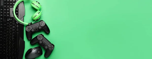 Modern gaming accessories on green background with space for text