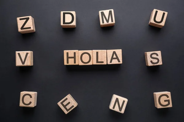 Word Hola Hello Made Wooden Cubes Dark Background Top View — Stock Photo, Image